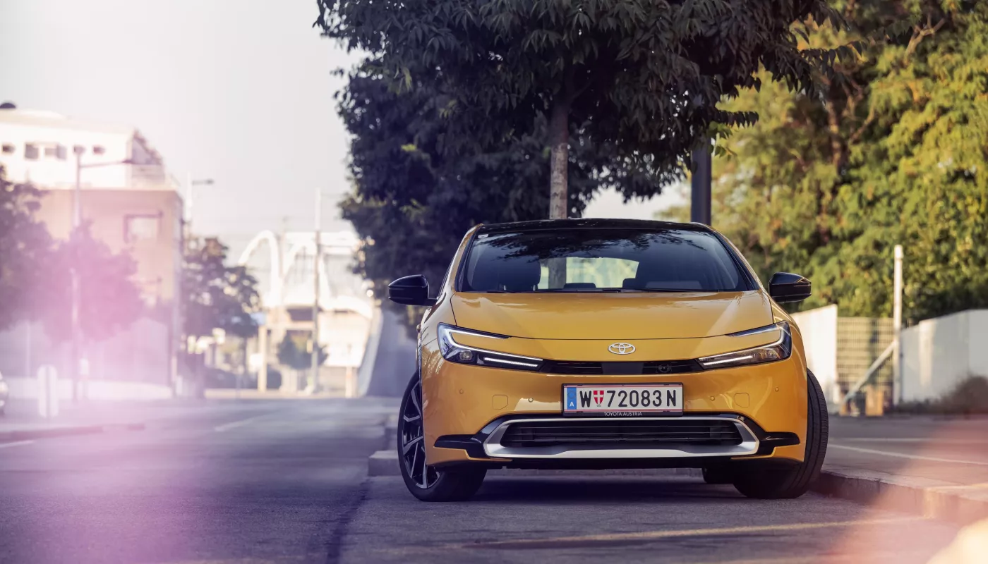 Ein Toyota Prius auf einem Parkplatz vor Bäumen